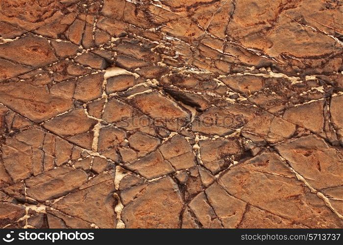 Cracked stone texture with red clay dust closeup