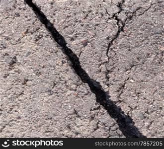 Cracked tarmac, deep wide hole and unrepaired