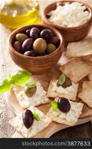 crackers with soft cheese and olives. healthy appetizer