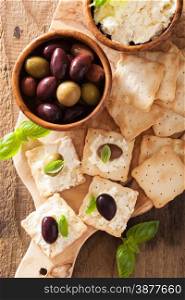 crackers with soft cheese and olives. healthy appetizer