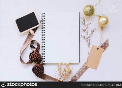 Craft and notebook mock up with christmas ornaments on white wood background