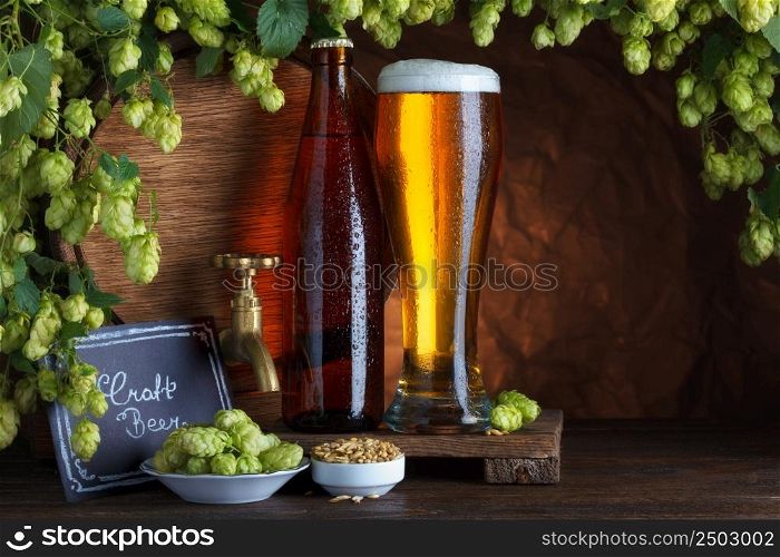 Craft bottled and unbottled beer with barrel, barley and fresh hops for brewing still-life
