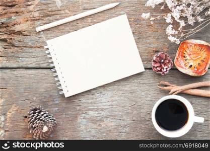 Craft notebook, pencil, cup of coffee on antique wooden table, Flat lay fall and winter