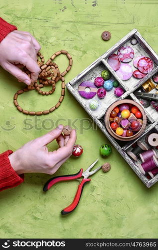 craft women jewelry. Women hands collecting the bracelets and beads