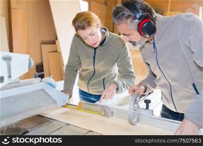 craftsman and carpenter working as a team cutting wood