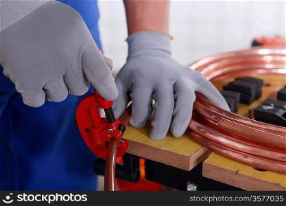 craftsman cutting a pipe