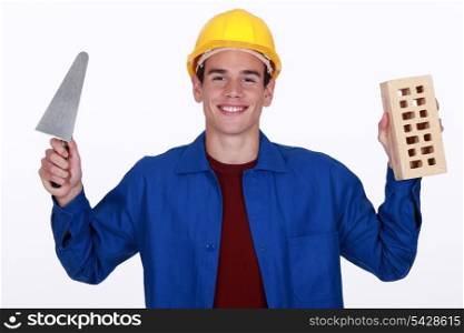 craftsman holding a brick and a trowel