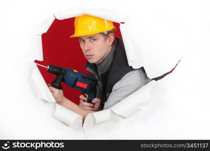 craftsman holding a drill and breaking a paper wall