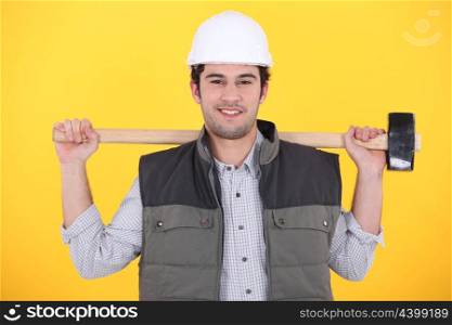 craftsman holding a huge hammer on his shoulders