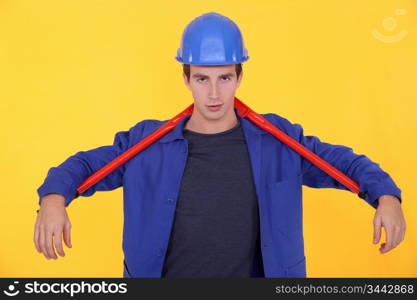 craftsman holding a huge spanner behind his neck
