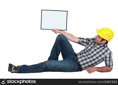 craftsman lying and holding a blank board
