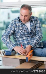craftsman measuring a plank of wood with a spirit level