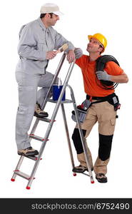 craftsman painter on a ladder speaking with a colleague