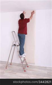 craftsman putting wallpaper