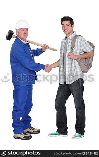 Craftsman shaking hands with apprentice