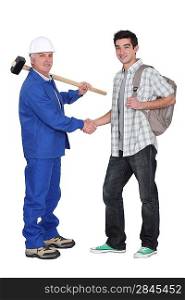 Craftsman shaking hands with apprentice