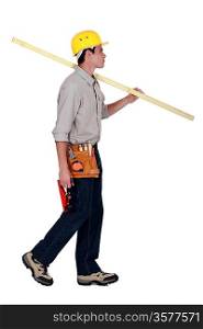 craftsman walking and holding a wooden board
