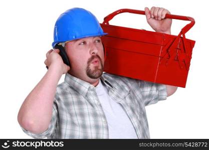 craftsman wearing headphones and carrying a tool box