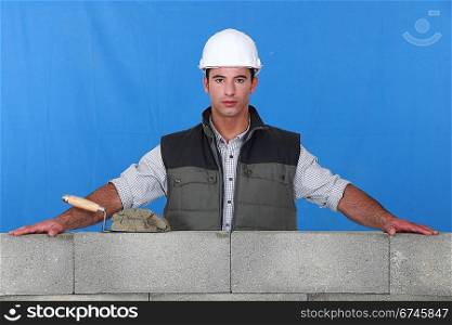 Craftsman with his arms resting on concrete wall