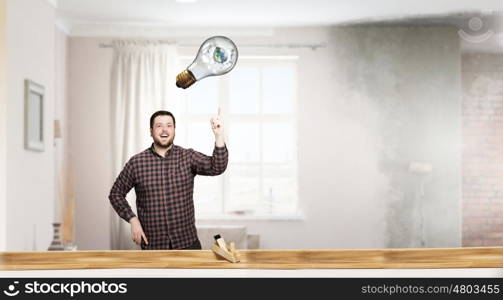 Craftsman working with plane. Young man in checked shirt with plane in room