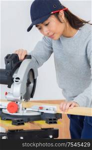 craftsperson woman uses circular saw cutting wood
