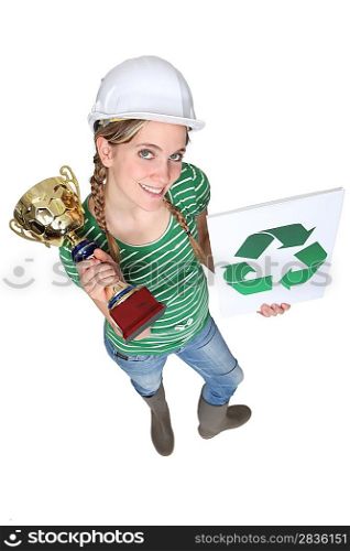 craftswoman holding a recycling label and a golden cup