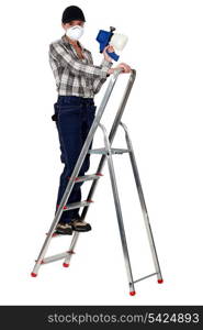 craftswoman on a ladder holding a sprayer and wearing a mask