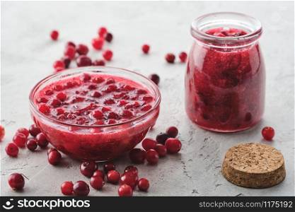 Cranberry jam in a glass bowl on a gray background