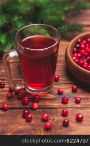 Cranberry tea in a glass cup on a wooden table. Cranberry tea in a glass cup