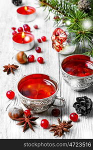 Cranberry tea in stylish iron cups at the Christmas background. Christmas tea party