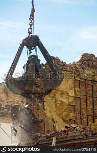 Crane destroying wall for construction