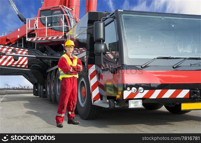 Crane driver, posing next to the huge mobile crane he&rsquo;s operating