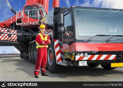 Crane driver, posing next to the huge mobile crane he&rsquo;s operating