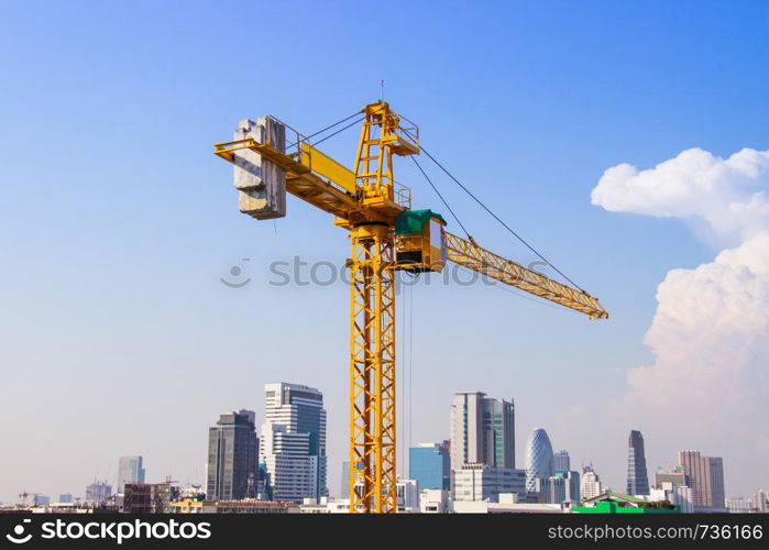 Crane is used in the construction of high buildings for tool of large industry under the blue sky and white clouds.