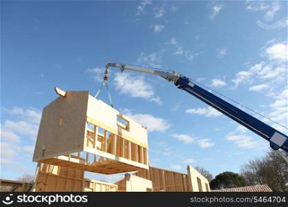 Crane lifting the framework of a house