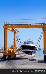 crane travelift lifting a boat on blue sky day in balearic islands
