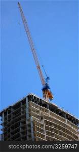 Crane working on partly-constructed building.