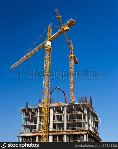Cranes and scafolding surround a high rise under construction