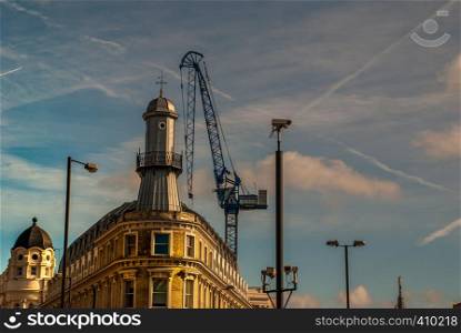 Cranes on buildings that are under construction in London. Low angle view.