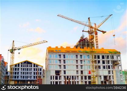 Cranes working at construction site of modern apartments building, real estate business, Kiev, Ukraine