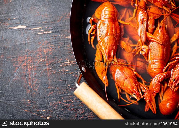 Crayfish are boiled in a saucepan. Against a dark background. High quality photo. Crayfish are boiled in a saucepan.