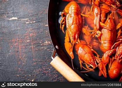 Crayfish are boiled in a saucepan. Against a dark background. High quality photo. Crayfish are boiled in a saucepan.