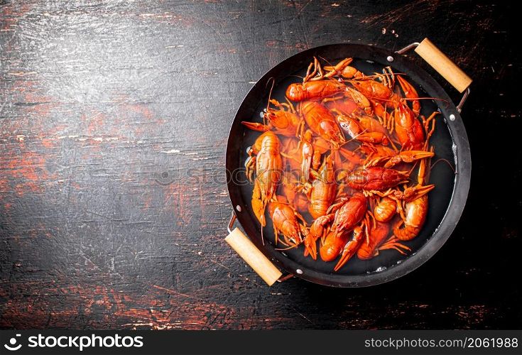 Crayfish are boiled in a saucepan. Against a dark background. High quality photo. Crayfish are boiled in a saucepan.