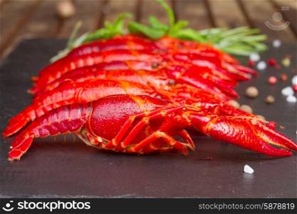 Crayfish. Row of big red boiled Crayfish on black board with spices