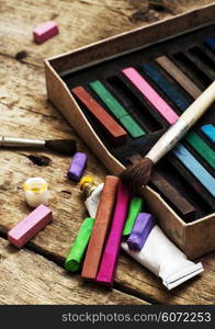 Crayons and paints. Crayons and paints for painting on wooden background