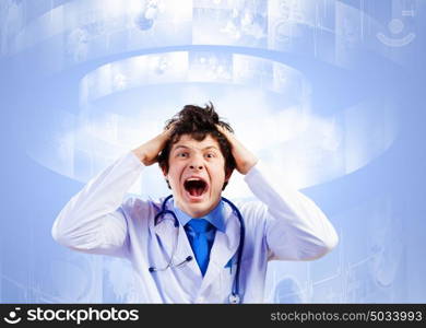 Crazy doctor. Image of young male doctor screaming in madness