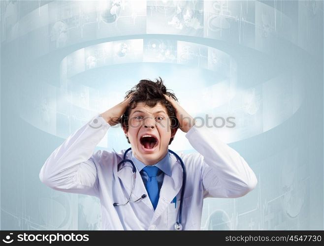 Crazy doctor. Young mad doctor in white uniform screaming
