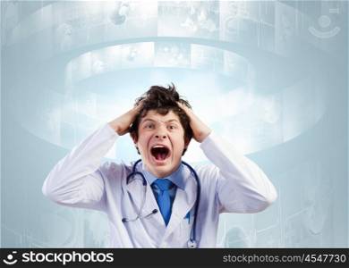 Crazy doctor. Young mad doctor in white uniform screaming