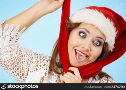 Crazy funny woman wearing festive Santa Claus red hat fooling around, making weird faces, mad about Christmas.. Crazy Christmas woman