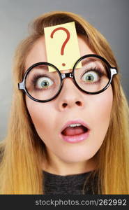 Crazy wondering face expression concept. Wierdo nerd woman having question mark on forehead and geek eyeglasses.. Weirdo nerd woman having question mark on forehead